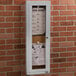 An Aarco satin anodized indoor bulletin board cabinet with a paper menu inside.