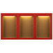 A row of red Aarco bulletin board cabinets with glass doors and lights.