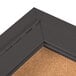 A bronze metal enclosed bulletin board with a cork interior.