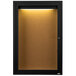 A black framed cabinet door with a cork bulletin board inside and a light.