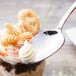 A Chef & Sommelier stainless steel dessert spoon with whipped cream on top.