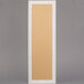 A rectangular white frame with a tan board and door.