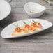A Schonwald white porcelain long tray with food in a white bowl.