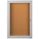 A white enclosed bulletin board cabinet with a satin anodized door.