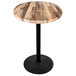 A round wooden table with a black base.