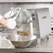 A person using a Hobart power drive unit to grind food.