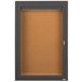 A brown cork board cabinet with a bronze anodized finish and a key lock on the door.