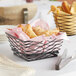 An American Metalcraft square black metal birdnest basket filled with pastries on a table.
