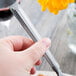 A hand holding a Libbey stainless steel utility/dessert fork