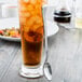 A glass of iced tea with a Libbey stainless steel iced tea spoon in it.