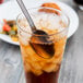 A glass of iced tea with a Libbey stainless steel iced tea spoon in it.