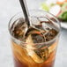 A glass of iced tea with a Libbey stainless steel iced tea spoon in it.