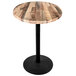 A round wooden table with a black base.