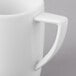 A close-up of a Schonwald white porcelain mug with a handle.