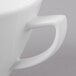 A close-up of a Schonwald Avanti Gusto white porcelain cup with a handle.