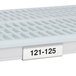 A white plastic MetroMax i label holder with black numbers on a white surface.