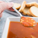 A Libbey stainless steel round bowl soup spoon filled with soup.