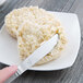 A Libbey stainless steel bread and butter knife on a plate with butter.