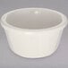 A white Carlisle ramekin with a white rim on a gray surface.