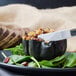 A plate of food with a Libbey stainless steel steak knife on it.