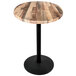 A round wooden table with a black round base.