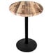 A round wooden table with a black base.