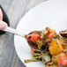 A Libbey stainless steel serving spoon in a plate of food.