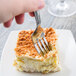 A Libbey stainless steel dinner fork in a piece of cake.