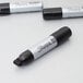 A close up of a Sharpie Magnum black permanent marker.