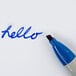 A close up of a blue Sharpie marker writing "hello" on white paper.