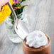 A person holding a Master's Gauge stainless steel dessert spoon over a glass of chocolate pudding.