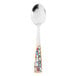 A World Tableware stainless steel teaspoon with a colorful pebblestone design on the handle.