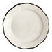 An Acopa ivory stoneware plate with scalloped edges and a black rim.