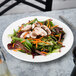 A Villeroy & Boch white porcelain plate with salad, chicken, and carrots on it.