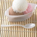 A bowl of ice cream with a Fineline Tiny Tasters white plastic tasting spoon.