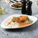 A Villeroy & Boch white porcelain oval plate with chicken curry and rice on a table.