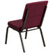 A burgundy patterned church chair with a gold metal frame.