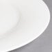 A close-up of a Villeroy & Boch white porcelain plate with a white rim.