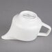 A white porcelain creamer with a handle.