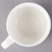 A Villeroy & Boch white porcelain cup on a gray surface.