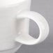 A close-up of a Villeroy & Boch white porcelain coffee cup with a handle.