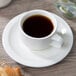 A Villeroy & Boch white porcelain cup of coffee on a saucer.