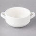 A close up of a white Villeroy & Boch porcelain soup cup with two handles.