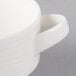 A close-up of a stackable white Villeroy & Boch porcelain soup cup with a handle.