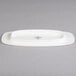 A white porcelain Villeroy & Boch oval plate with black text on it.