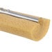 A roll of yellow sponge with a metal object on it.