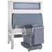 A grey rectangular Follett ice storage bin with a rectangular ice cart inside.