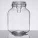 An Anchor Hocking clear glass Hermes jar with a metal lid on a table.