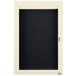 An ivory cabinet with a black hinged door and black letter board inside.