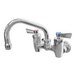 A silver Fisher wall mount faucet with two lever handles and a swing nozzle.